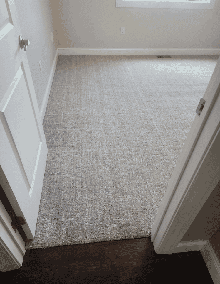 white area rug on hardwood floor with couch and art prints